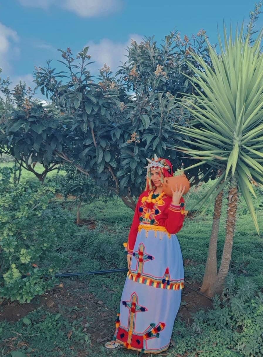 Tenue traditionnelle et jarre en terre, dans le verger