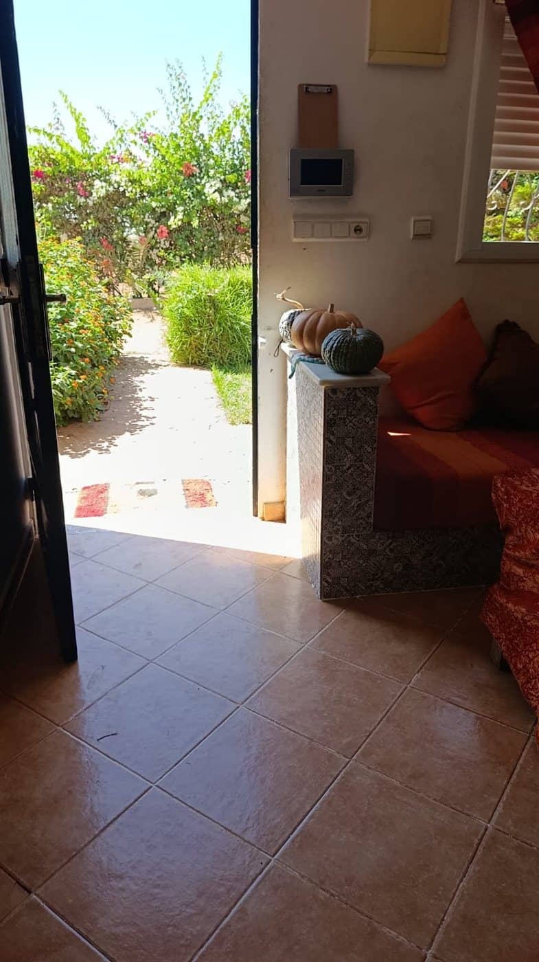 La porte de la maison ouverte sur le jardin, vue de l'intérieur