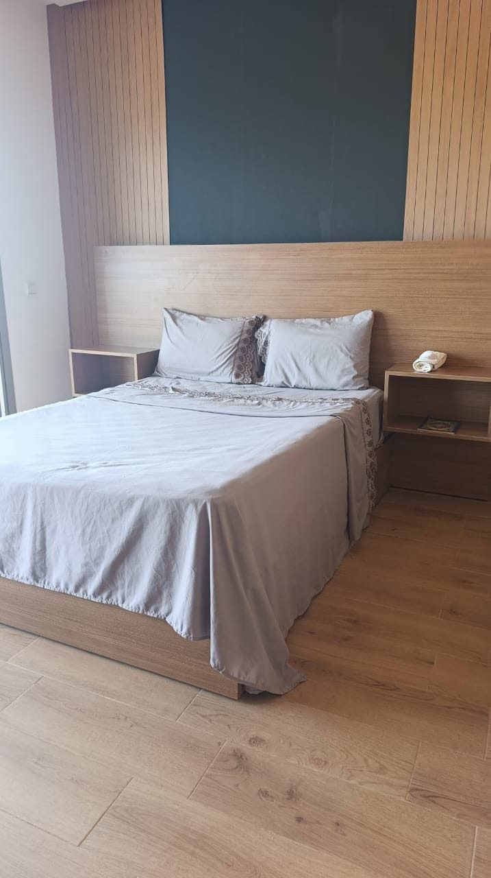 Une chambre avec lit double et tête de lit en bois
